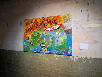 Das Gemälde „Von Löffeln, Helau und der Sehnsucht nach Köln“ von Jasmin Meirose ausgestellt bei der Kunstroute Ehrenfeld. Das farbenfrohe Werk hängt an einer rauen Betonwand und zeigt humorvolle, karnevalistische Motive mit Dinosauriern und Köln-Bezug. Die kontrastreiche Umgebung betont den lebendigen Charakter des Bildes.